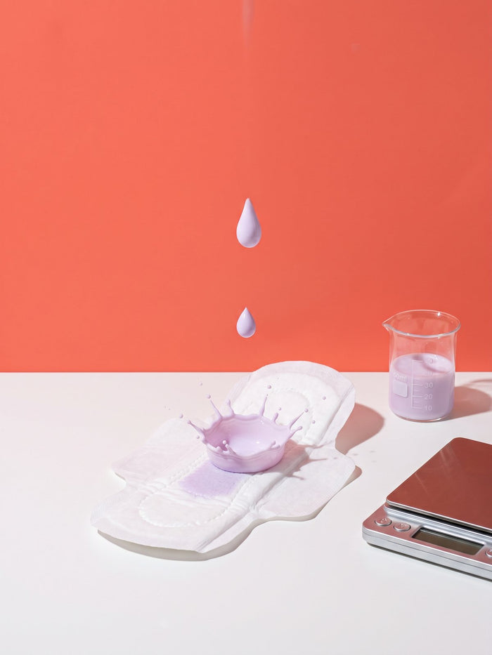Liquid drop absorbed by a LiZZOM ultrathin pad next to a measuring beaker