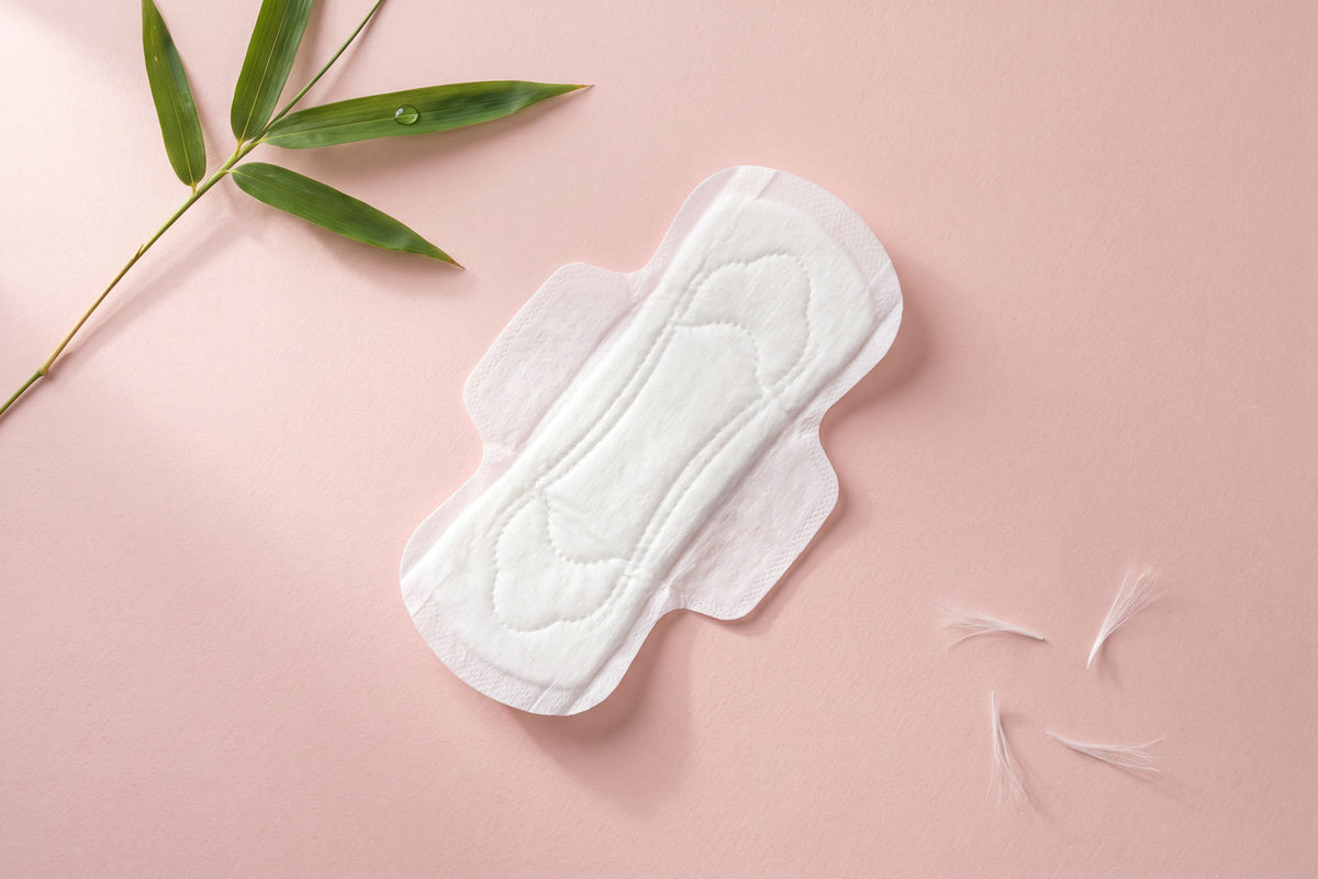 LiZZOM ultra-thin organic pad with wings — flat-lay with bamboo leaf