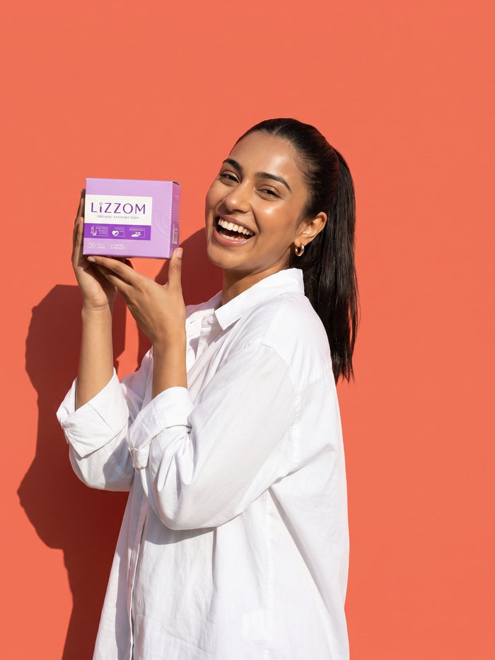 Woman laughing while holding a LiZZOM liners box